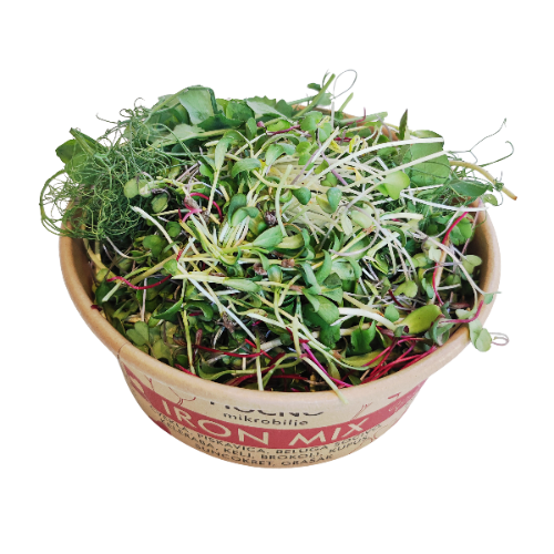 Detailed close-up of the open Iron Mix container. The dense texture of beetroot, spinach, kale, and broccoli microgreens is visible, with characteristic red and green shades.