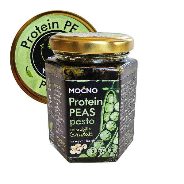 Central view of a hexagonal glass jar of MOĆNO Protein Peas pesto spread. Clearly visible black label with pea illustration and golden lid with a green "Protein Peas" sticker.