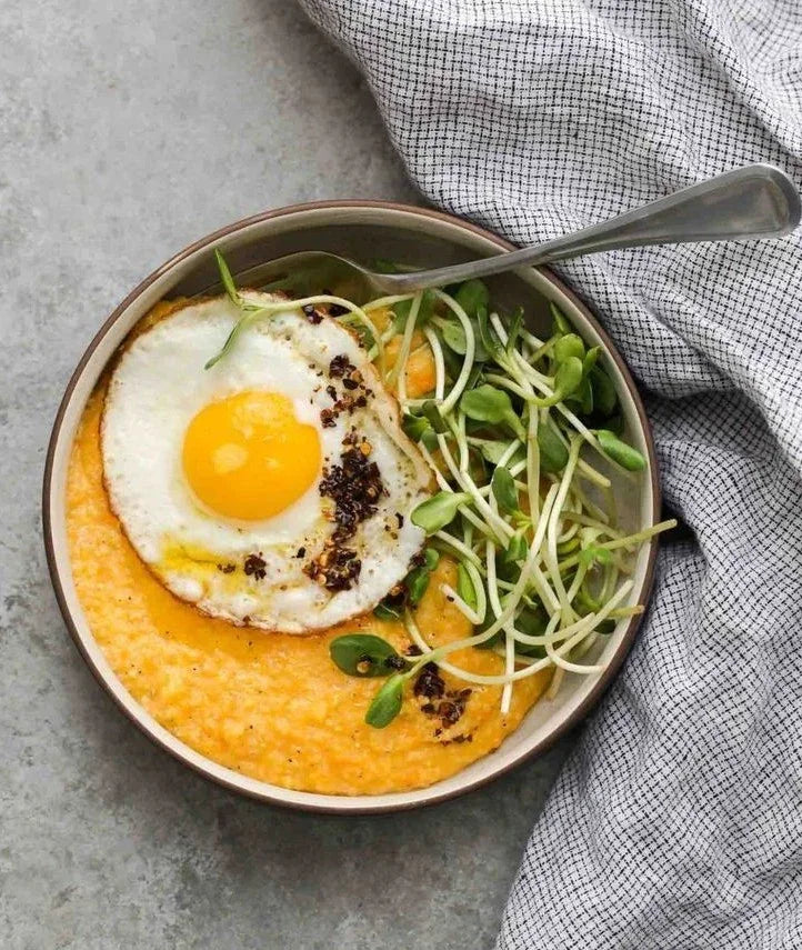 Serviran zdrav obrok sa prženim jajetom i svežim mikrobiljem suncokreta kao nutritivnim dodatkom.