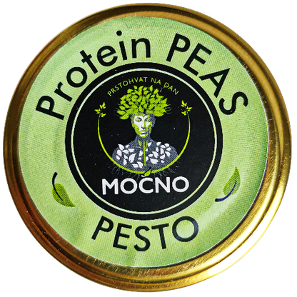 Kadar poklopca tegle odozgo. U fokusu je kružna svetlozelena etiketa sa MOĆNO logotipom i nazivom "Protein Peas Pesto", koja vizuelno odvaja ovaj ukus od ostalih namaza u asortimanu.
