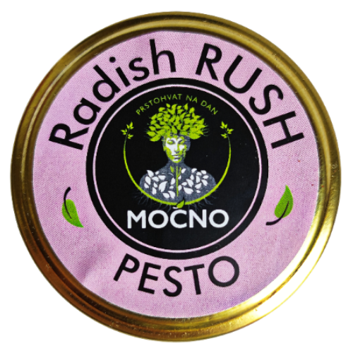 Kadar poklopca tegle odozgo. U fokusu je ljubičasta kružna etiketa sa MOĆNO logotipom i nazivom "Radish Rush Pesto", koja simbolizuje pikantnost i bogatstvo vitamina A, C i E.